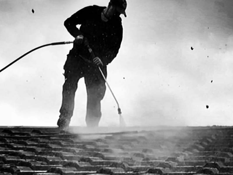 Powerwashing moss and dirt off a roof