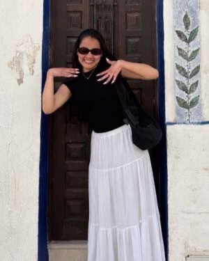 Andrea standing in a blue-framed doorway, smiling
